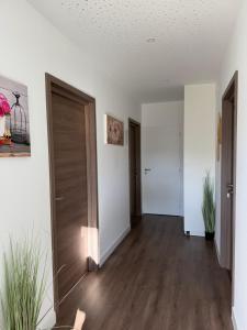 an empty living room with white walls and wooden floors at Le 6 by Montélimar in Montélimar