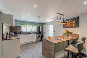 a kitchen with a island in the middle at Botanic Cottages in Southport