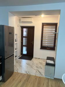 a kitchen with a refrigerator and a door to a room at Emanuela Apartments in Pecica Veche