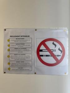a sign on a wall with a no smoking sign at Le 6 by Montélimar in Montélimar