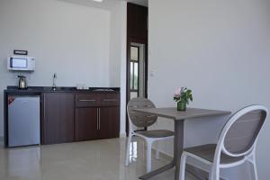 a kitchen with a table and chairs and a counter at Villa Olivera Hotel in Tḩūm at Taḩtā