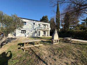 a house with two picnic tables in front of it at Le 6 by Montélimar in Montélimar