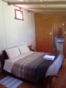 a bedroom with a bed with two white towels on it at Alojamiento junto al mar in Chaitén