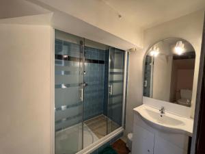 a bathroom with a glass shower and a sink at Wood & Cosy in Thizy-les-Bourgs