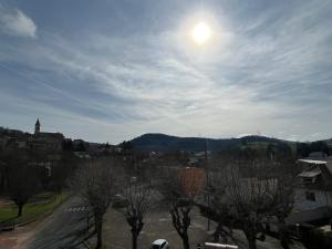 a view of a city with the sun in the sky at Wood & Cosy in Thizy-les-Bourgs