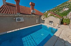 a swimming pool in the side of a house at Holiday Home Ivanino in Dubrovnik