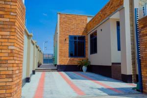 a brick building with a red stripe on the sidewalk at Nadyapartment in Dodoma