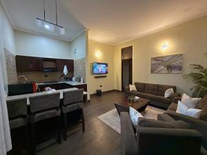 a living room with a couch and a table and a kitchen at Nadyapartment in Dodoma