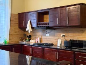 a kitchen with wooden cabinets and a black counter top at Nadyapartment in Dodoma