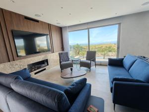 a living room with blue couches and a tv at Sunset Edge Villa - 77 Retreats in Għajn Tuffieħa