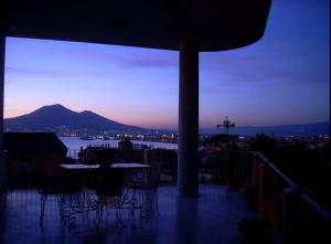 a table and chairs on a balcony at night at SergioCasa con vista a mare in Castellammare di Stabia