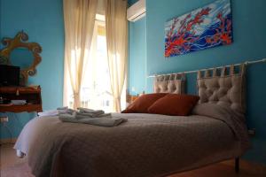 a bedroom with a bed with blue walls and a window at SergioCasa con vista a mare in Castellammare di Stabia