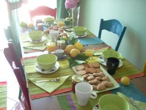 a table with breakfast foods and cups on it at SergioCasa con vista a mare in Castellammare di Stabia