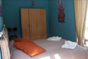 a bedroom with a bed with an orange pillow and a cabinet at SergioCasa con vista a mare in Castellammare di Stabia +4 photos