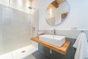 a bathroom with a white sink and a mirror at Le Vie del Borgo | 3 dimore indipendenti a Civita in Civita +25 photos