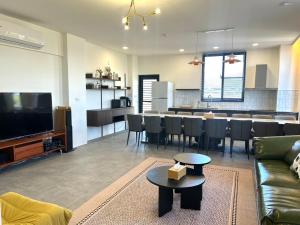 a living room with a couch and a table and a kitchen at Yutian B&B in Zhuangwei