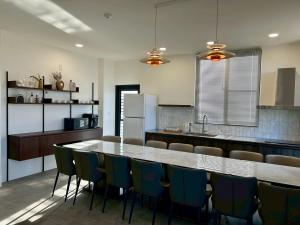 a kitchen with a table and chairs and a refrigerator at Yutian B&B in Zhuangwei