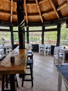a restaurant with a table and chairs and windows at Hosteria EL REFUGIO in Aluminé +22 photos