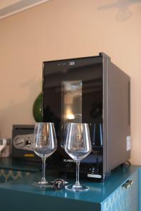two wine glasses on a counter next to a microwave at Lo splendore dei Sassi in Matera