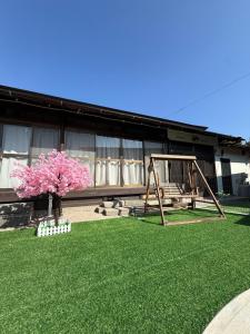 a playground with a swing and a tree at yumigahama Eaglehouse in Minamiizu