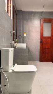 a bathroom with a toilet and a red door at Mollusca Beach Villa in Waskaduwa +36 photos