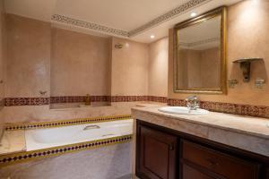 a bathroom with a tub and a sink and a mirror at Villa BALRA une maison d'hôtes au coeur du centre ville in Rabat