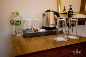 a counter with two empty glasses and a coffee maker at Serene Lake View Resort in Anuradhapura