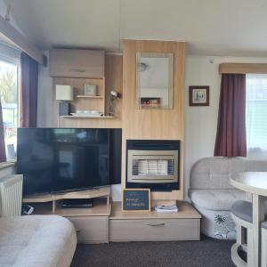 a living room with a large flat screen tv at Carmels Caravan Borwick Lakes in Carnforth