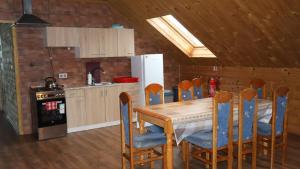 a kitchen with a table and chairs and a refrigerator at Górska Chata u Kota in Huta Szklana