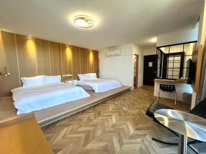 a hotel room with two beds and a table at Yutian B&B in Zhuangwei