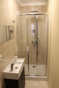 a bathroom with a shower and a white sink at Lama Rooms in Warsaw +24 photos