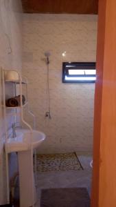 a bathroom with a white sink and a window at Maison Manour Studio 4 personen in Mbour