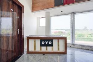 a wooden box with the oo on it in a room with windows at Hotel O Highway Kitchen in Bara Khera