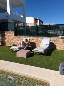 a woman laying on a lawn reading a magazine at Chalet Barceló Rocher in Cala d´Or