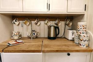 a kitchen counter with cups and a coffee pot on it at Morndyke Shepherds Huts in Thirsk +23 photos
