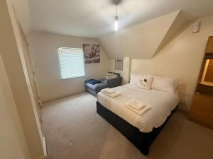 a bedroom with a large bed and a couch at Comfort Arena in Colchester