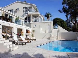 a house with a swimming pool next to a building at Grande Hotel in Cape Town