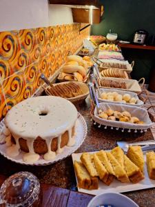 a buffet with many different types of cakes and pastries at Suítes Praia Barequeçaba in São Sebastião