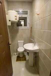 a small bathroom with a toilet and a sink at horizon sky pyramids in Cairo