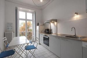a kitchen with white cabinets and a sink and a window at L'intemporel, gîte de charme pour 4 à 5 personnes in Saint-Gervais-la-Forêt