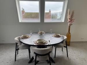 a dining room table with plates and glasses and a vase at The Corner -FRANS in Beernem