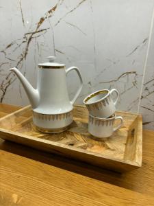 two tea pots and a cup on a wooden tray at The Gold Resident Airport Warszawa-Modlin in Nowy Dwór Mazowiecki +16 photos