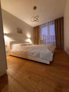 a bedroom with a white bed and a window at The Gold Resident Airport Warszawa-Modlin in Nowy Dwór Mazowiecki
