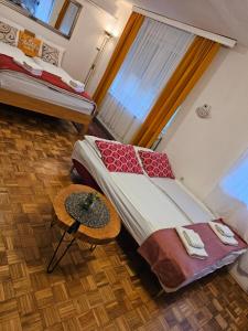a room with two beds with a table and a window at Happy apartment-OldTown Sarajevo in Sarajevo