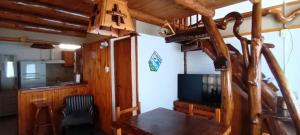 a dining room with a table and a television at Cabañas Mai-Hue in El Bolsón