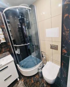 a bathroom with a shower and a toilet at G Apartments in Rēzekne