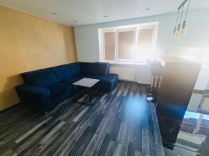 a living room with a blue couch and a table at G Apartments in Rēzekne +2 photos