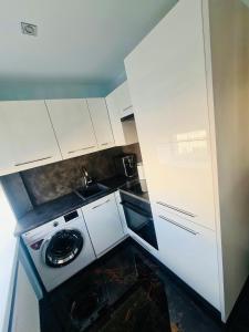a small kitchen with a washing machine in it at G Apartments in Rēzekne