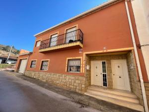 a orange building with a balcony on a street at Ca Ona in Chella