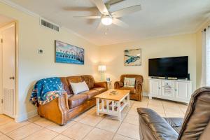 a living room with a couch and a flat screen tv at Cute Cocoa Beach Condo w/ Pool & Beach Access! in Cocoa Beach